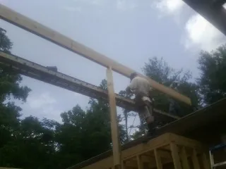 Carpenter setting a ridge beam over a new addition frame — Ice Dam Removal by Roofing Brothers in Bahama