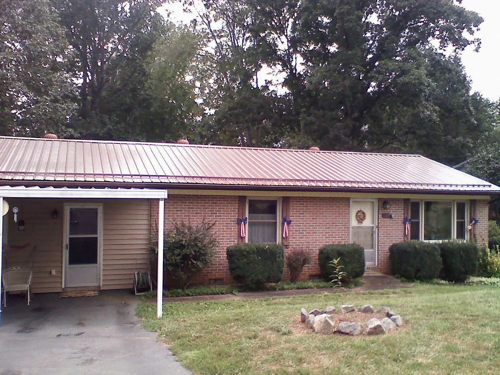 Bronze metal roof and carport on a brick ranch home — Roof Repair work by our crew in Bahama